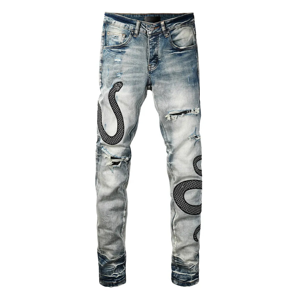 Man's blue distressed skinny jeans with a button fly and mid waist on a grey background.