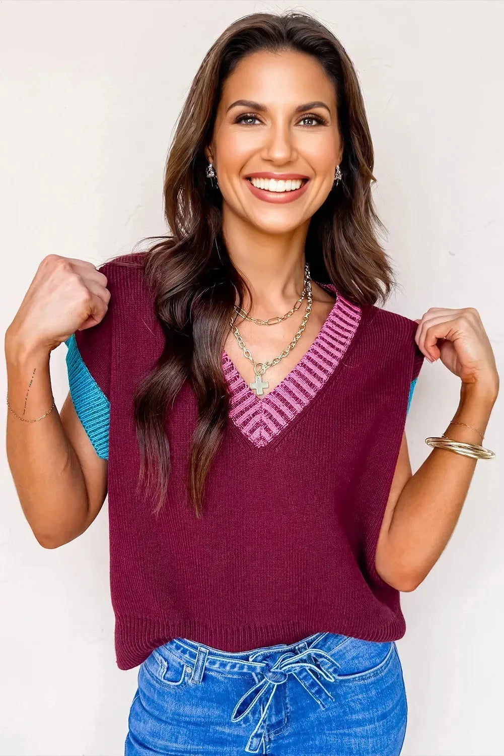 Burgundy loose sweater with V-neck, contrast trim, and cuffed short sleeves on a hanger.