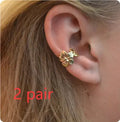 A pair of gold drop earrings featuring starfish and conch designs on an alloy base.