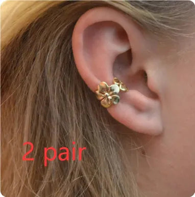 A pair of gold drop earrings featuring starfish and conch designs on an alloy base.