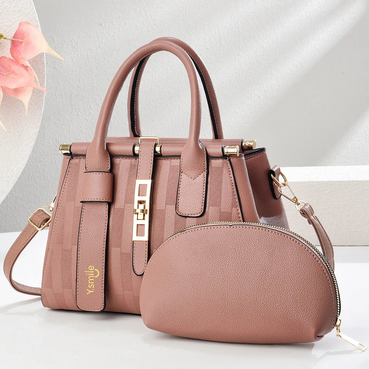 A pair of round black and light khaki PU leather crossbody bags with adjustable straps.