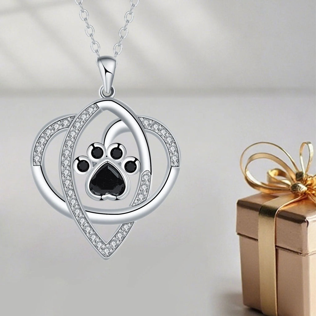 Copper pendant necklace showing a detailed cat and dog paw print design on a cross chain.