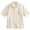 Light apricot men's shirt with bamboo plant pattern and Cuban collar on hanger