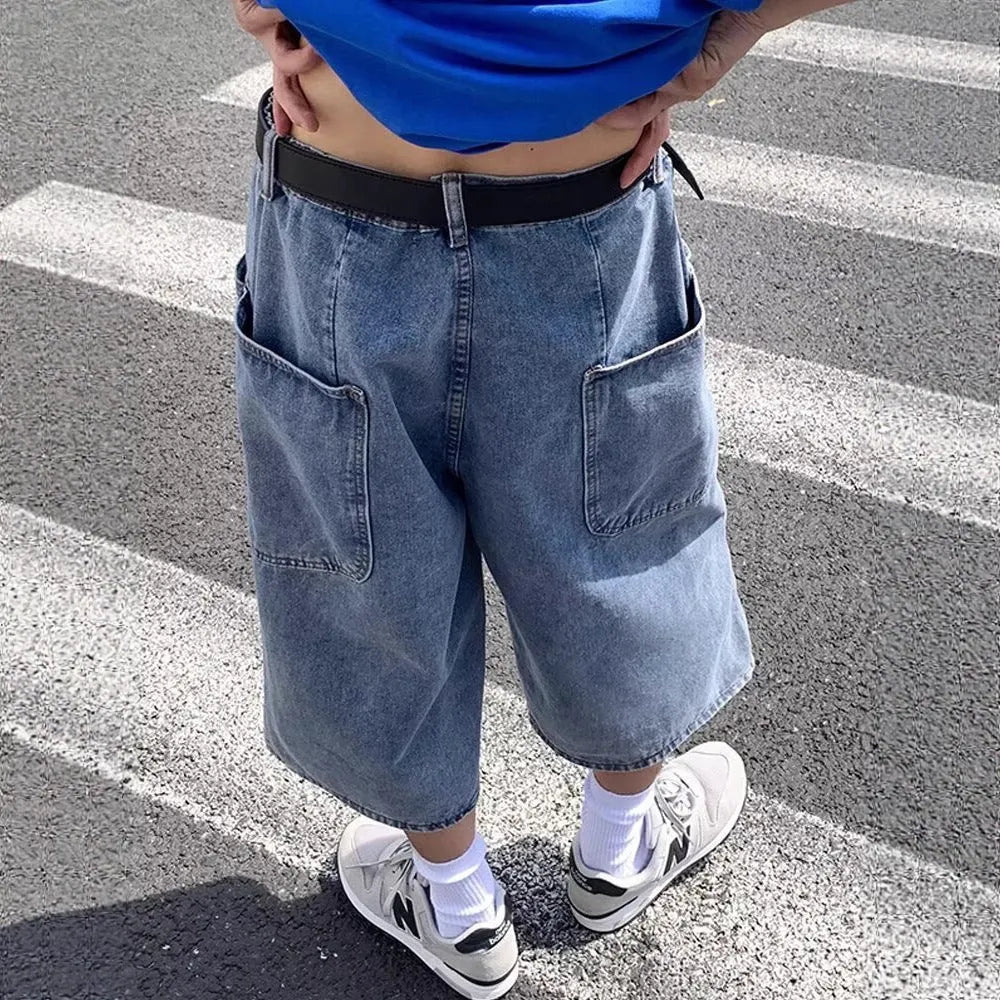 Man wearing blue washed denim shorts with a high waist, cropped leg, and straight cut.