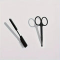 Black pet grooming brush with a soft rubber tear stain remover tool and a plastic comb on an ambidextrous handle.