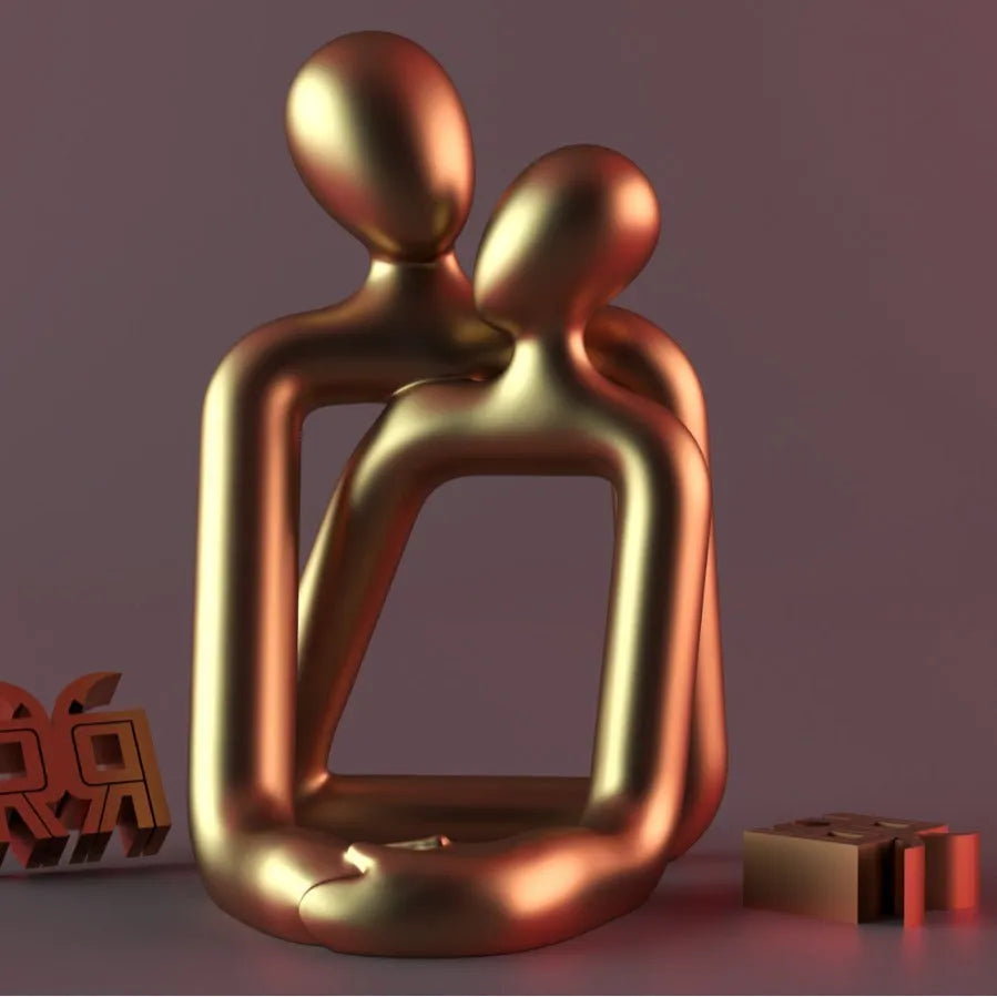 Modern resin statue of an embracing couple in milky white or gold finish on a wooden surface.
