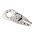 Black zinc alloy golf ball fork and bottle opener tool on green turf