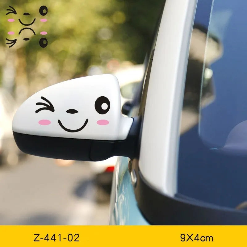A pair of reflective cartoon eye car stickers on a vehicle rearview mirror.