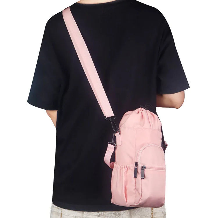 Canvas crossbody water bottle pouch in black green and pink holding a cup