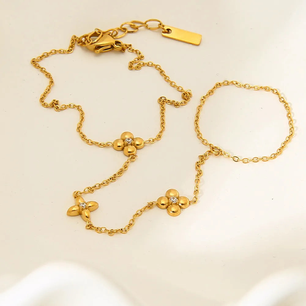 Gold stainless steel women's bracelet with floral and eight-pointed star geometric design.