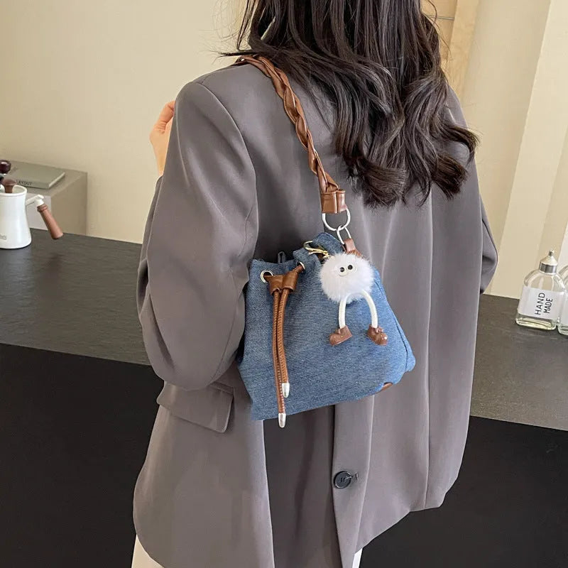 Blue one-shoulder cross body bucket bag with synthetic leather lining and hanging drop ornaments
