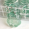 Acrylic four-leaf clover pendant charm for phone or keychain in blue or green colours.