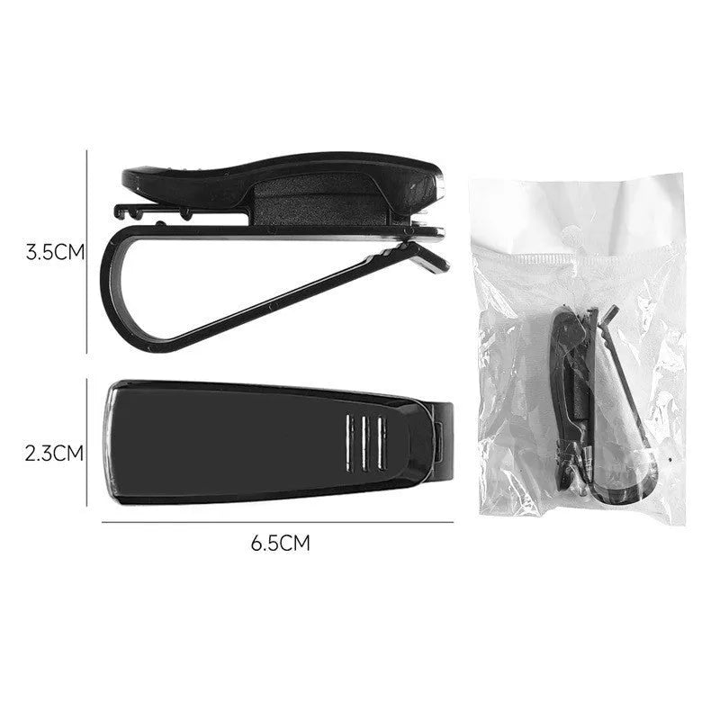 Black plastic car sunshade clip holding sunglasses and parking ticket