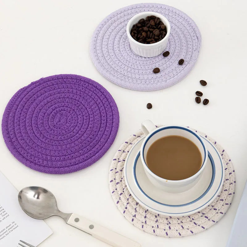 Set of three round grey cotton cord coasters on a wooden table, each 18cm in diameter.