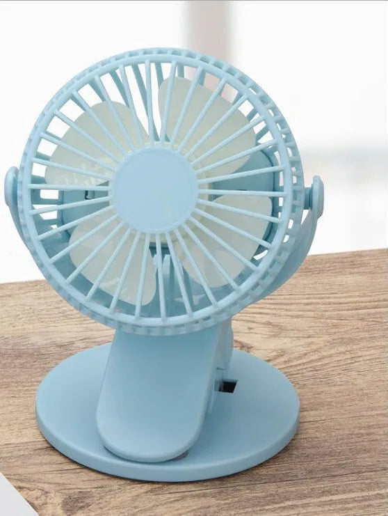 White USB rechargeable clip fan with plastic blades attached to a desk edge.