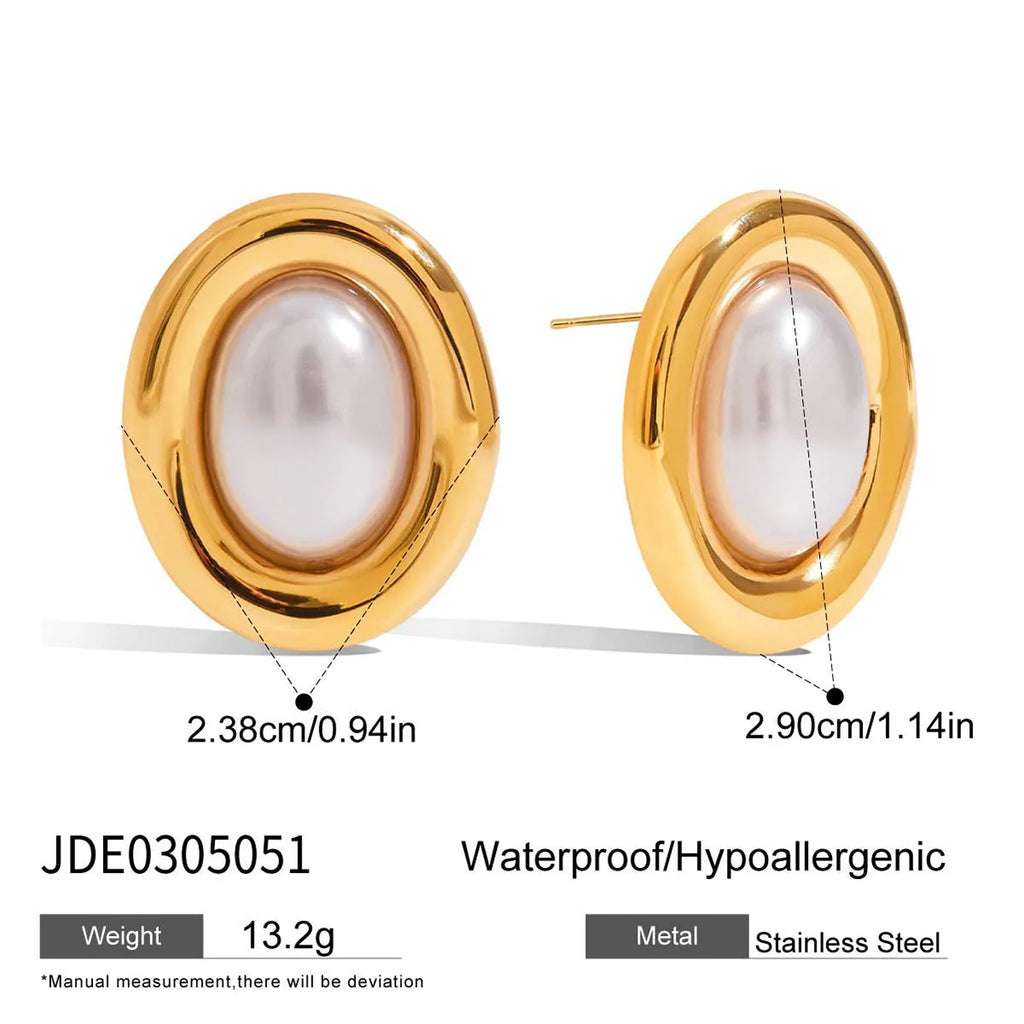Small gold-tone stainless steel stud earrings with a white pearl accent on a grey background.