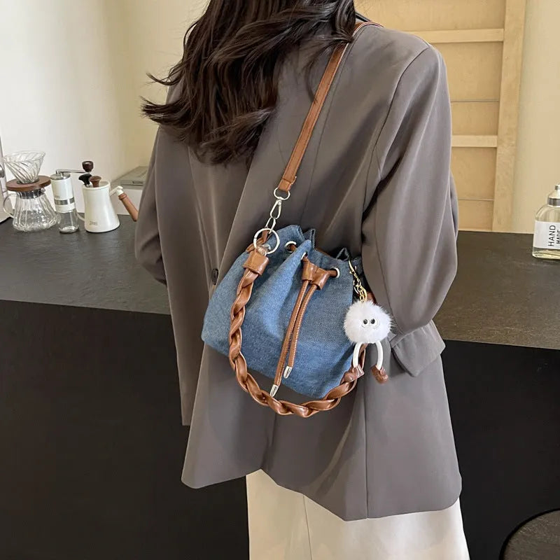 Blue one-shoulder cross body bucket bag with synthetic leather lining and hanging drop ornaments