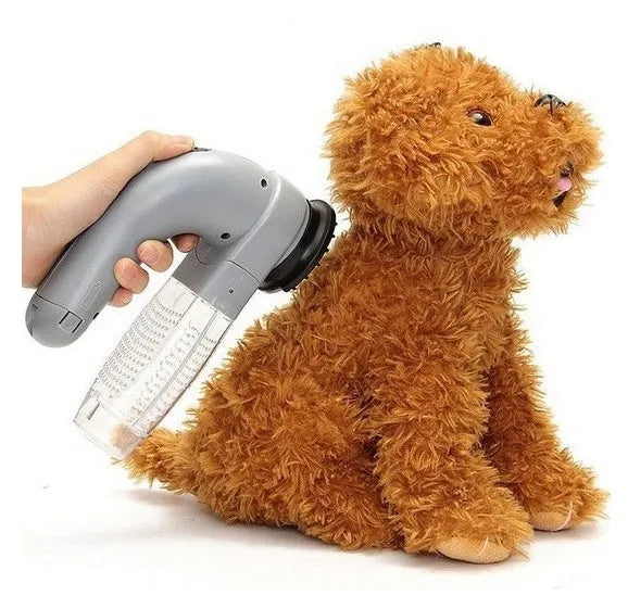 Grey handheld electric pet hair remover brush with soft rubber head, shown removing fur from upholstery.