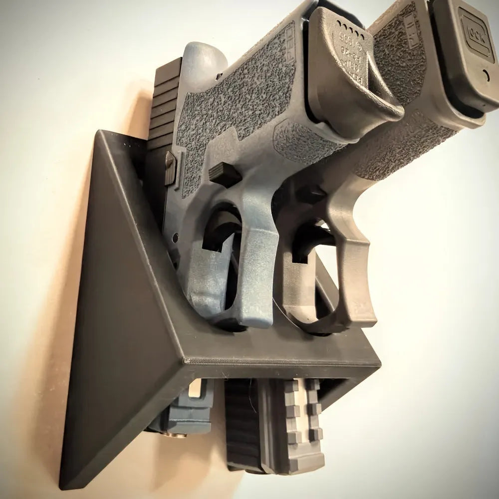 Black punk-style plastic pistol display stand measuring 10.85cm by 7.6cm