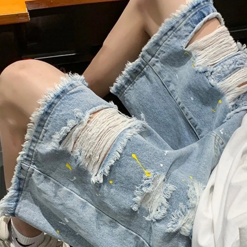 Men's loose fit water washed denim shorts with hole details in light blue, showing fifth pants length.