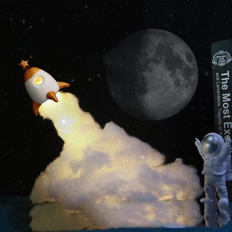DIY astronaut rocket night light kit with LED string lights, small model, and straws for assembly on a desk.