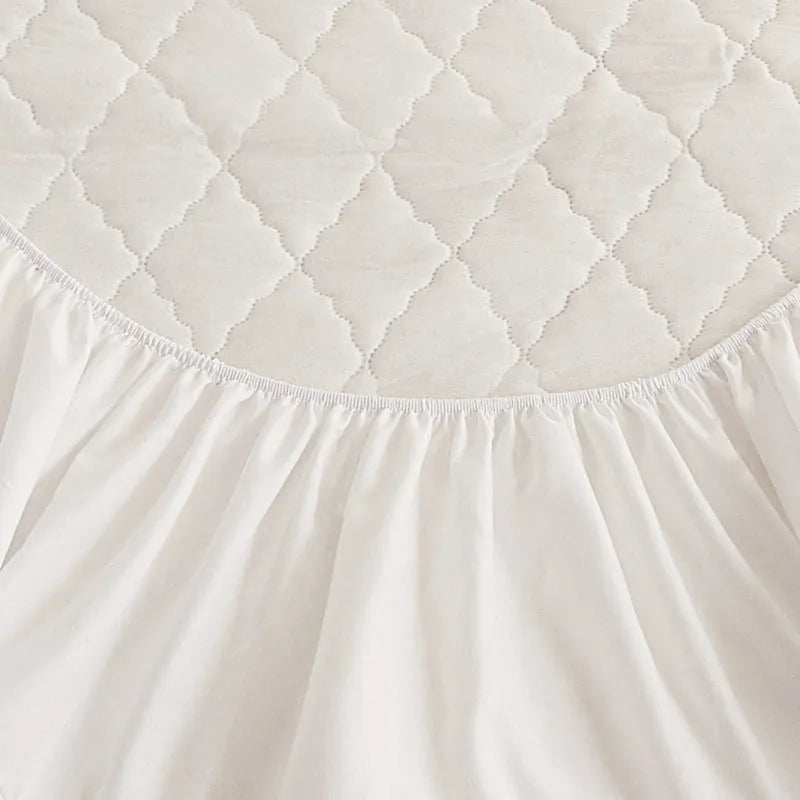 Diamond lattice quilted waterproof mattress protector in bamboo fibre shown on bed