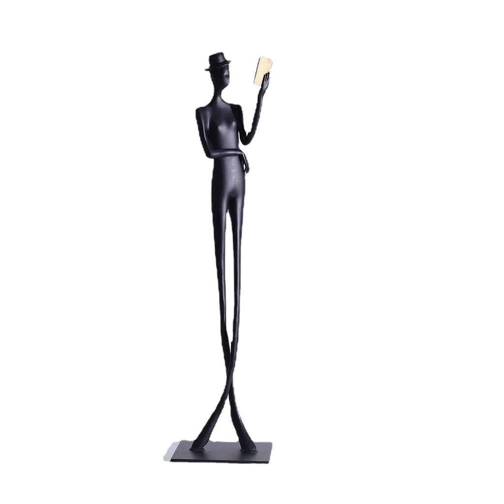 Black metal desktop sculpture of a woman reading, 51cm tall.