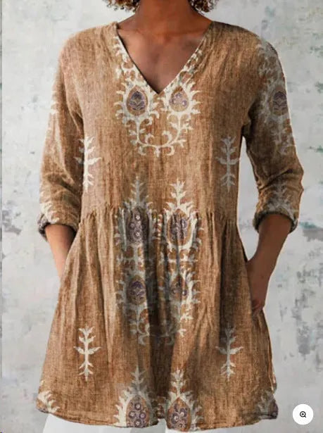 A woman wearing a printed, loose-fitting dress with a wide waist and three-quarter length sleeves.