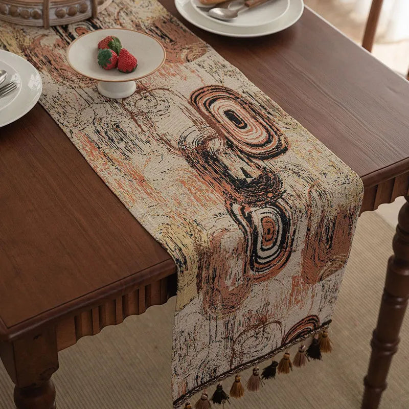 Dark blue Nordic Jacquard table runner with bouquet design and tassels laid on a wooden table.