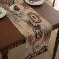 Dark blue Nordic Jacquard table runner with bouquet design and tassels laid on a wooden table.