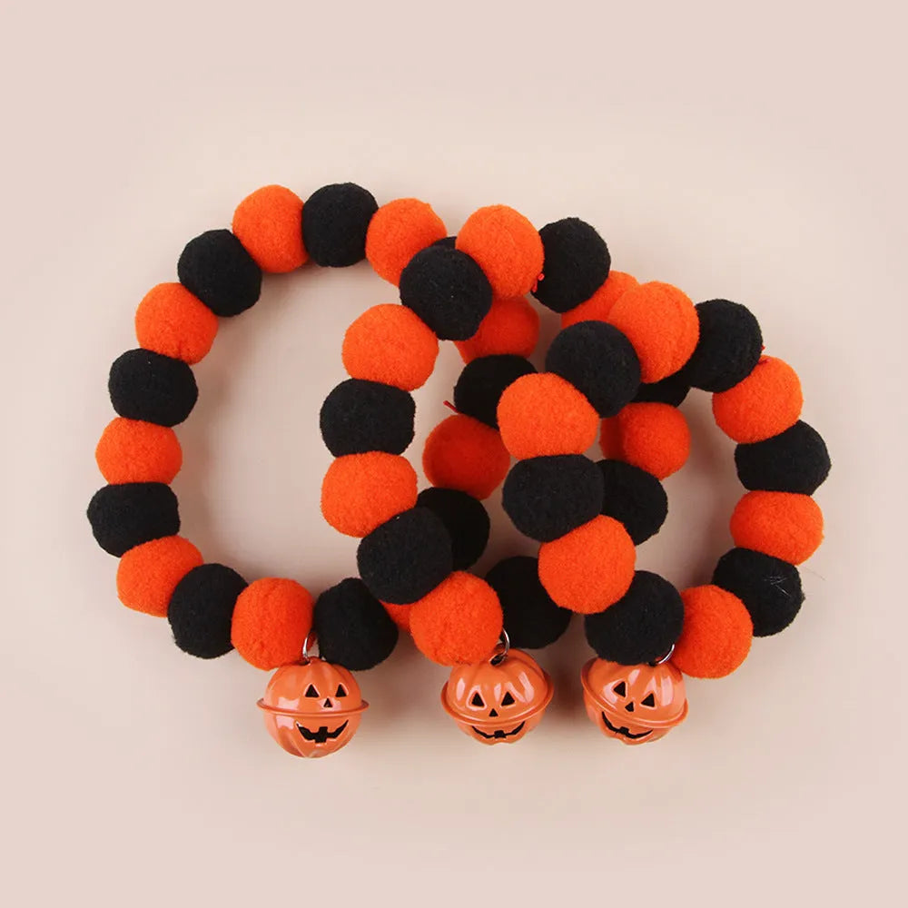 Orange Halloween cat collar with black jack-o'-lantern print and a small detachable fabric pumpkin basket.