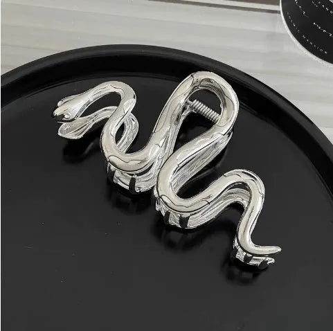 Silver metal hair claw clip assortment showing bows, waves, pearl designs, and geometric shapes from 4cm to 13.5cm