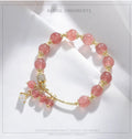 Women's pink strawberry quartz crystal bracelet with heart-shaped charms and pearl decorative elements