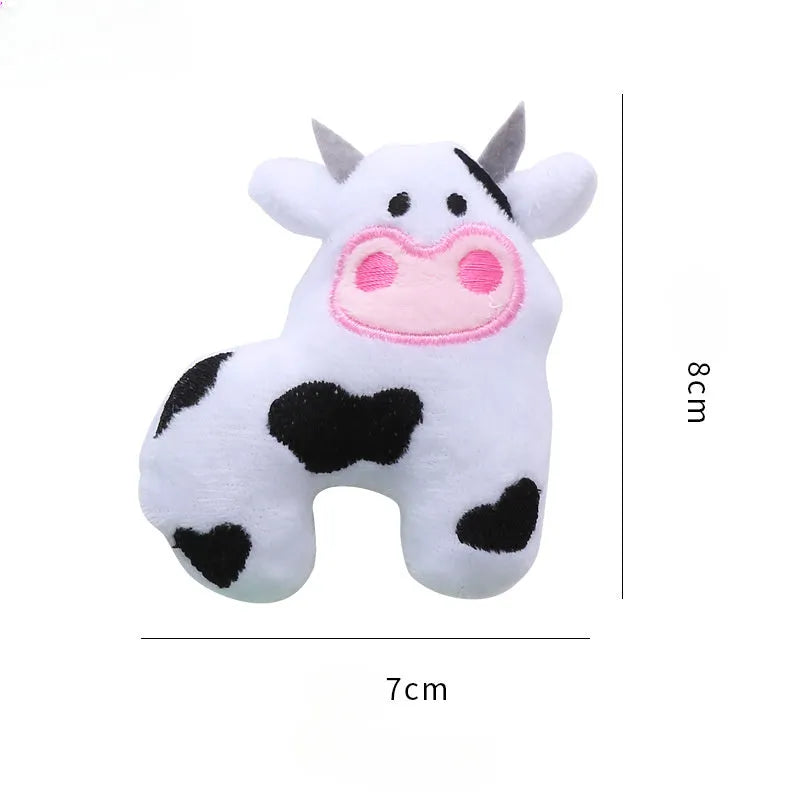 Soft plush cat toy shaped like a cow or parrot, filled with catnip, on a neutral background.