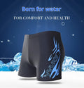Men's plus size blue fire print swimming trunks and matching swim cap on black background.