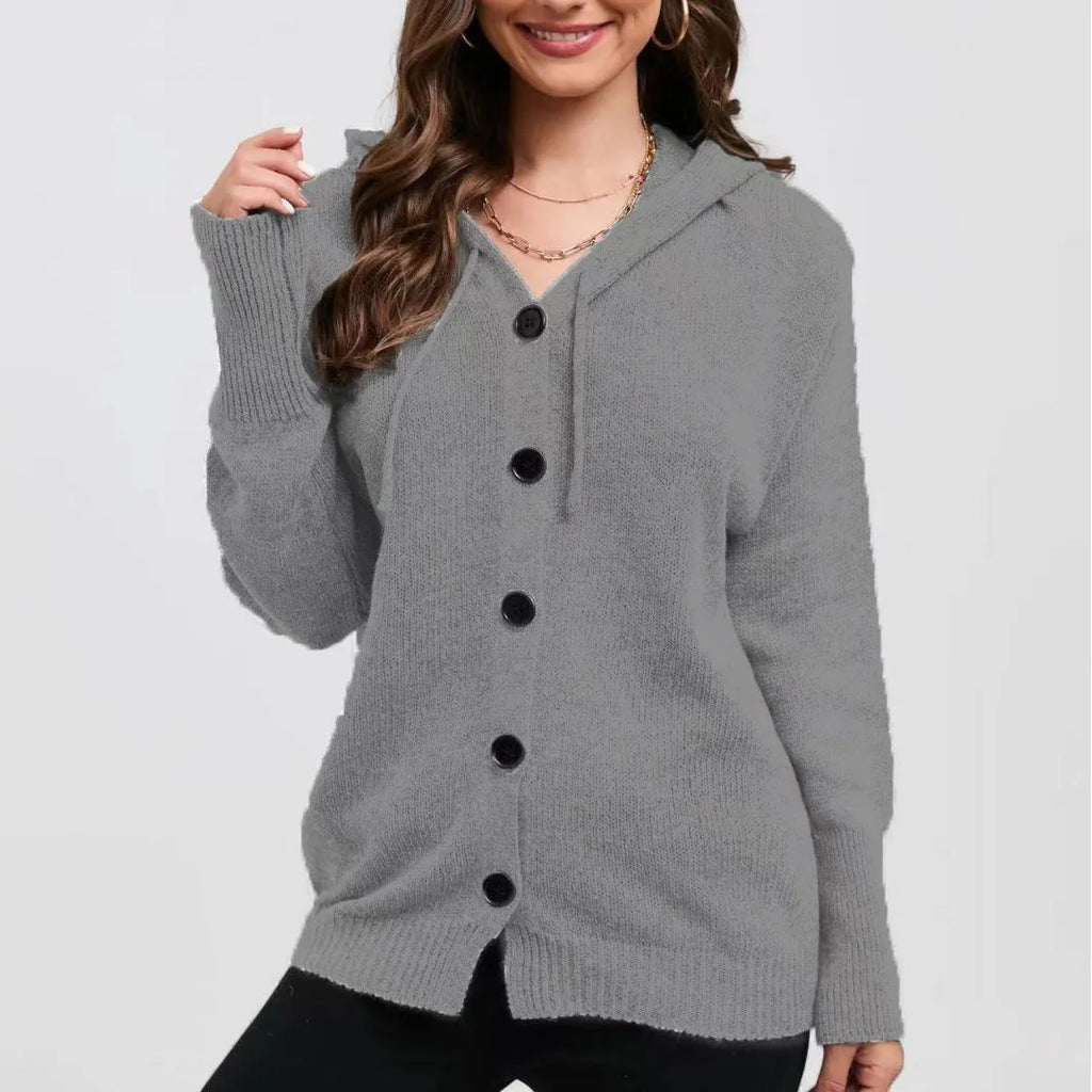 Woman wearing a thick, loose-fit grey hooded cardigan sweater with long sleeves.
