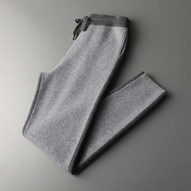 Men's navy blue cashmere blend knitted cardigan suit with half turtleneck and zip, paired with matching trousers.