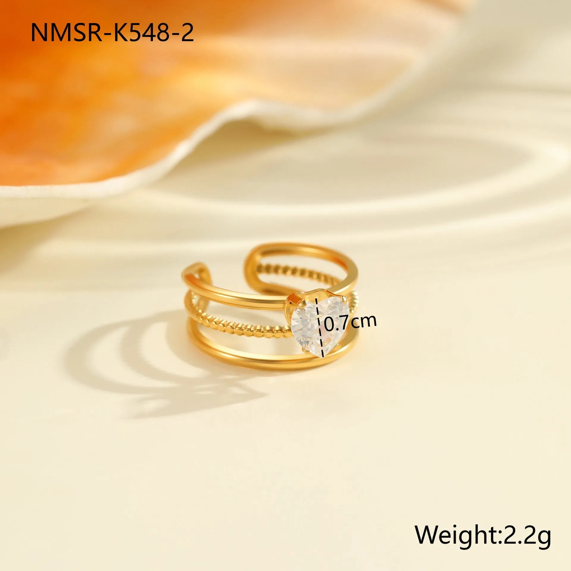 Gold-coloured stainless steel open ring with zircon stones in a geometric heart design.