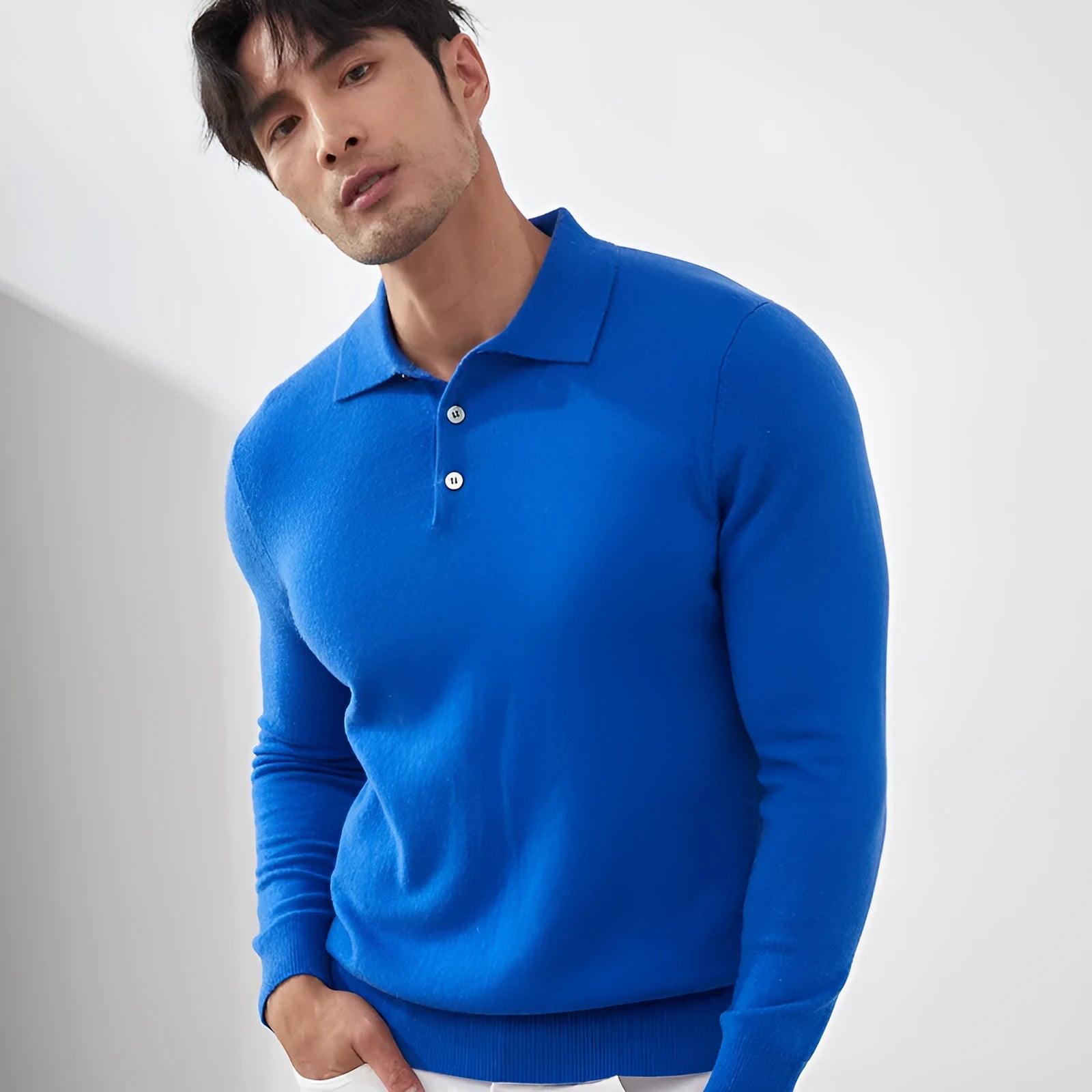 Man wearing a sapphire blue cashmere short sleeve pullover sweater with a polo collar.