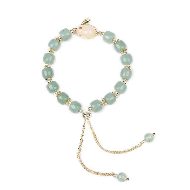 Rabbit charm bracelet with green aventurine or strawberry quartz beads on a gold-coloured adjustable chain.