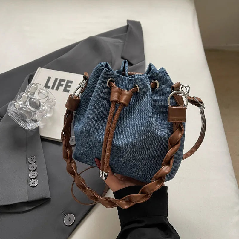 Blue one-shoulder cross body bucket bag with synthetic leather lining and hanging drop ornaments