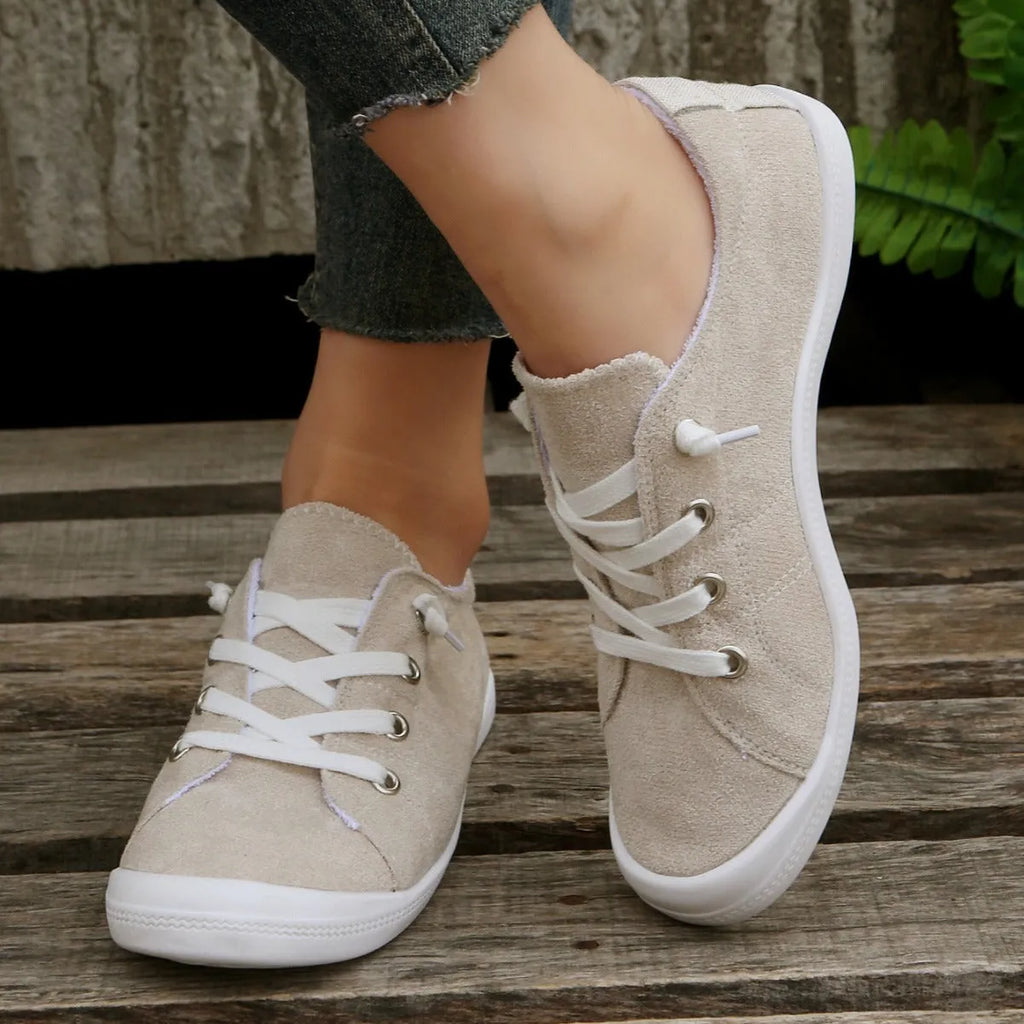 Women's creamy white low-top fabric sneakers with rubber soles on various surfaces