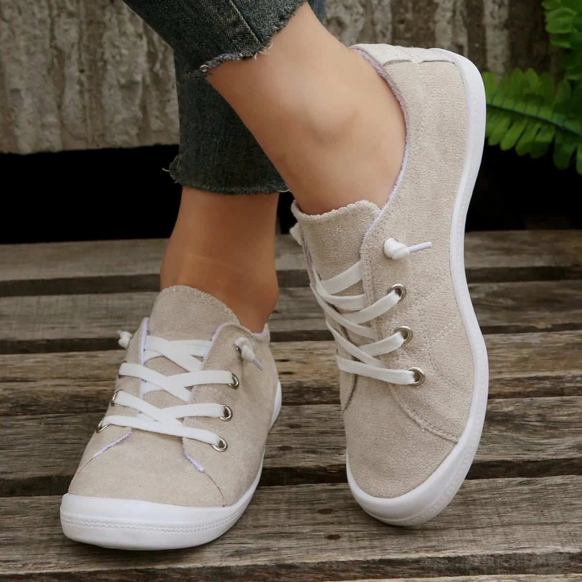 Women's creamy white low-top fabric sneakers with rubber soles on various surfaces