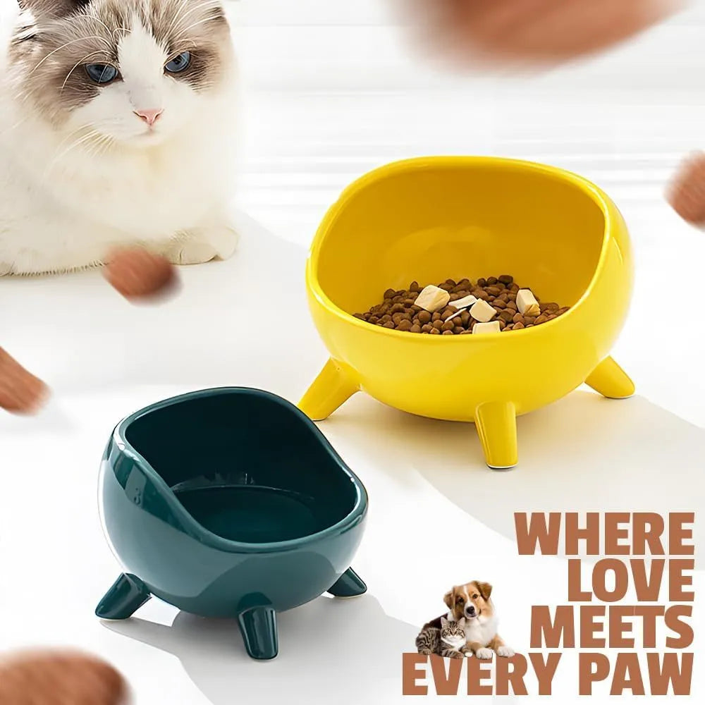 Green ceramic cat food bowl with four legs and rounded arc design on wooden floor