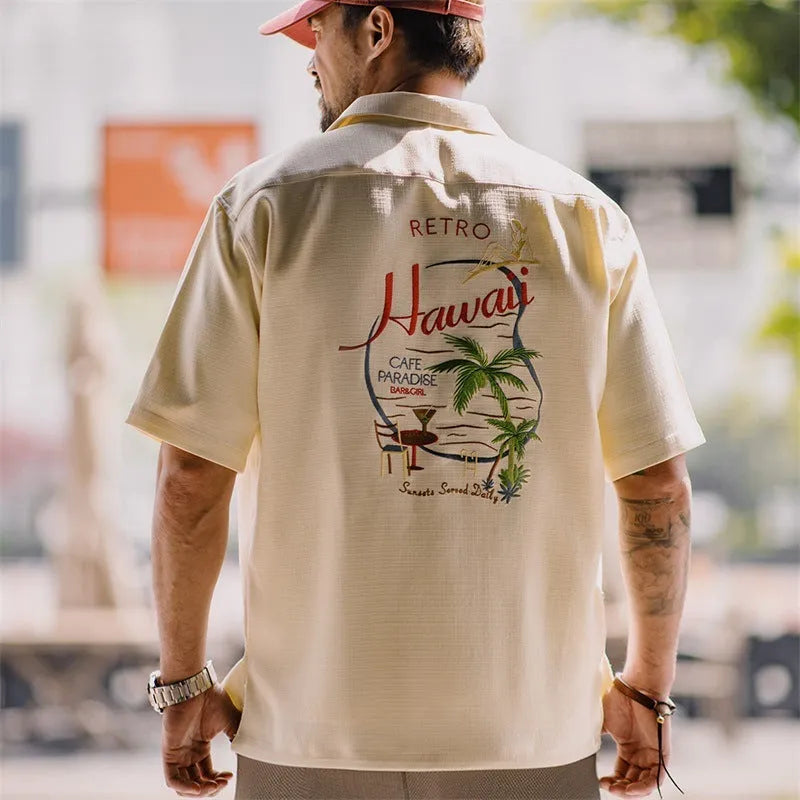 Light apricot men's shirt with bamboo plant pattern and Cuban collar on hanger