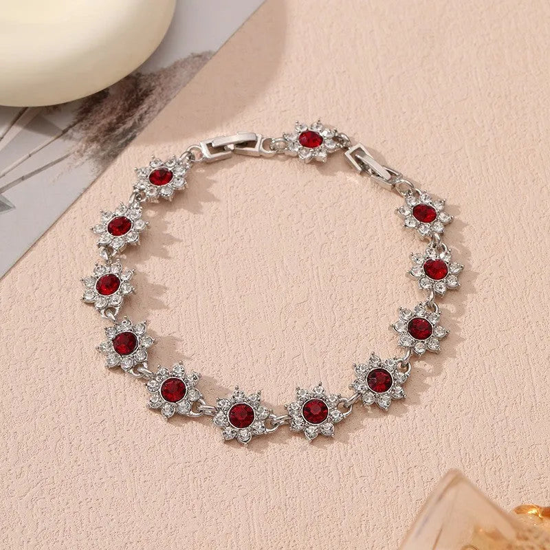 Electroplated zinc alloy flower bracelet in a choice of gold or silver finishes with coloured gemstone designs.