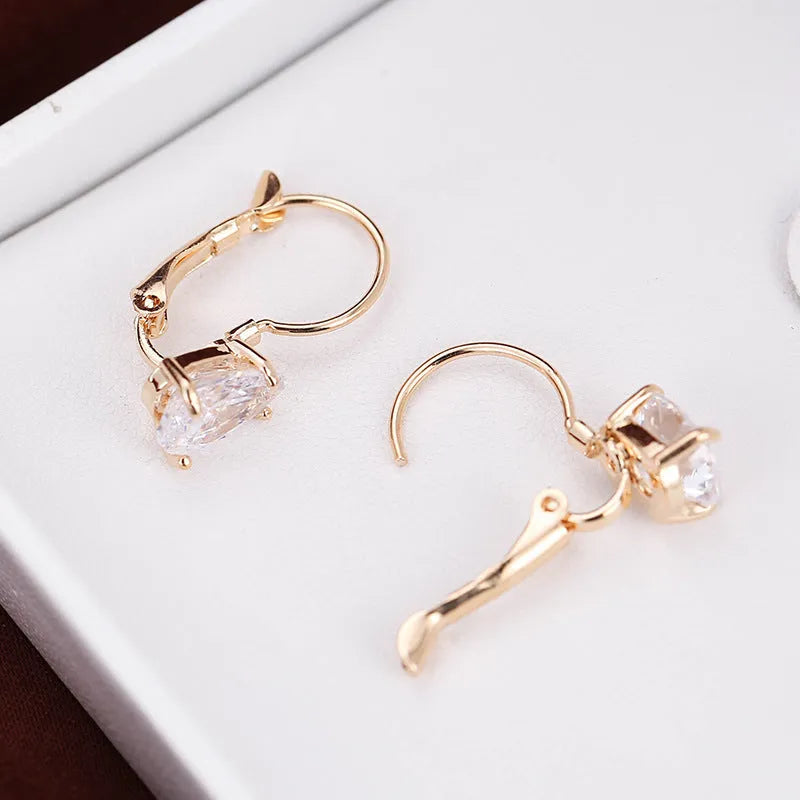 Drop-shaped metal earrings with platinum gem details in gold or platinum colour options
