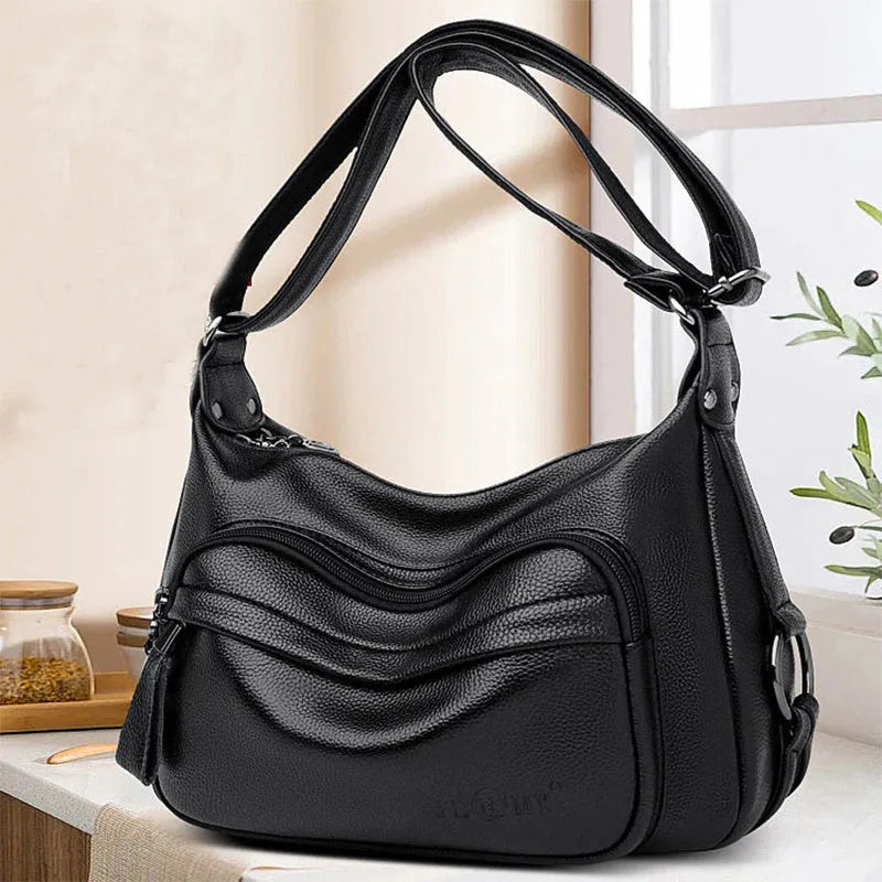 Large black PU shoulder bag with multiple internal compartments showing phone and document sections
