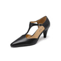 Women's brown retro T-strap closed toe sandals with a stout heel on a wooden surface