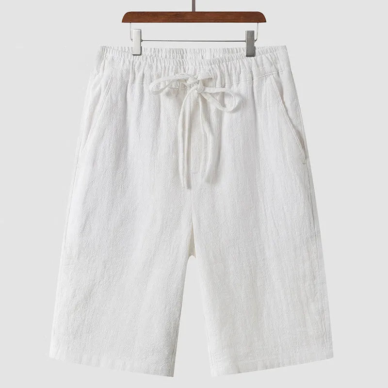 Men's linen shorts in loose cropped design with elastic waistband, shown in available colours
